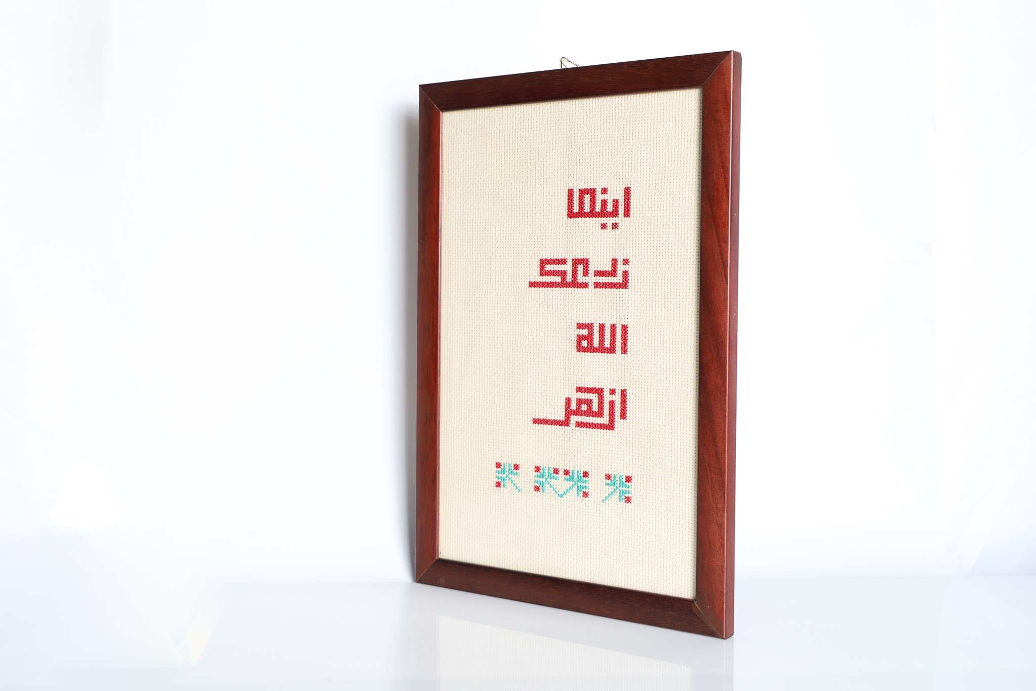 An embroidered frame with Kufic calligraphy.